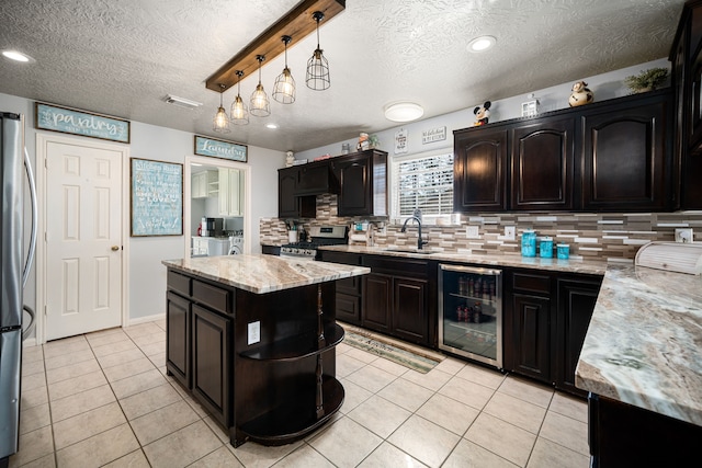 kitchen with light tile patterned floors, beverage cooler, visible vents, stainless steel appliances, and a sink