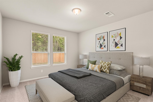 bedroom with light carpet, visible vents, and baseboards