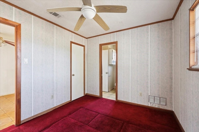 unfurnished bedroom featuring visible vents, crown molding, and ceiling fan