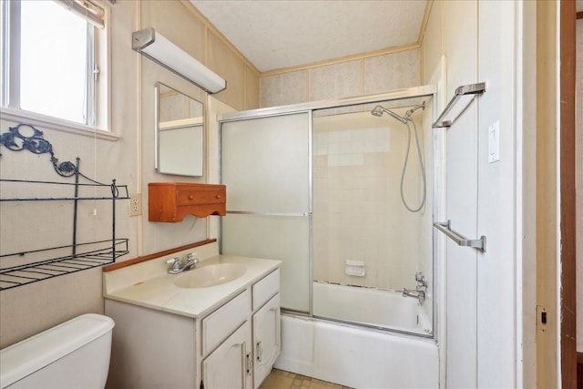 bathroom with toilet, shower / bath combination with glass door, and vanity