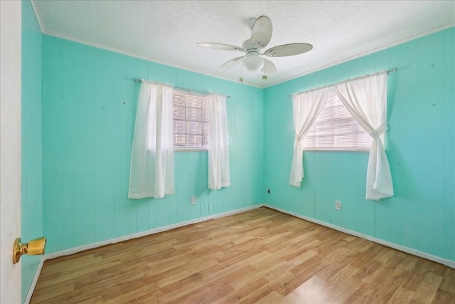 unfurnished room featuring baseboards, a ceiling fan, and wood finished floors