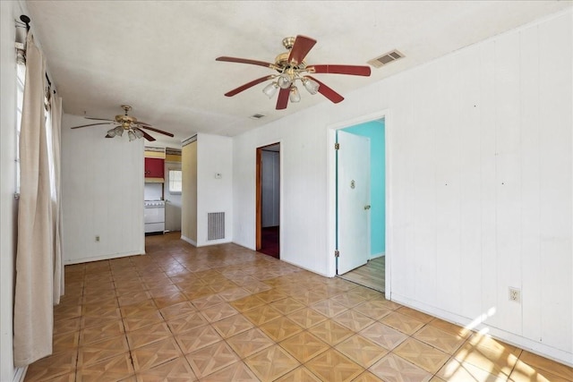 empty room with baseboards, visible vents, and ceiling fan