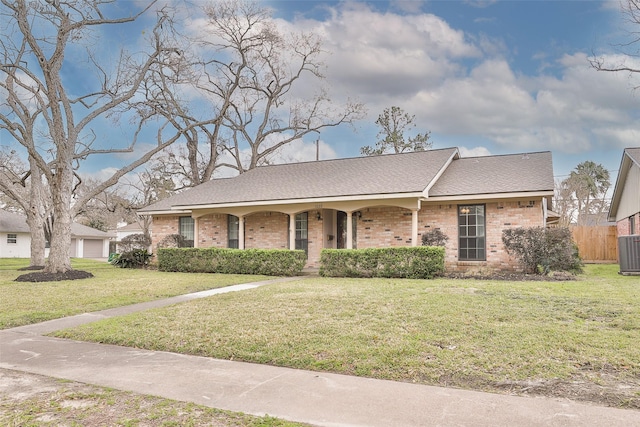 single story home featuring brick siding, a porch, a front yard, central AC, and fence