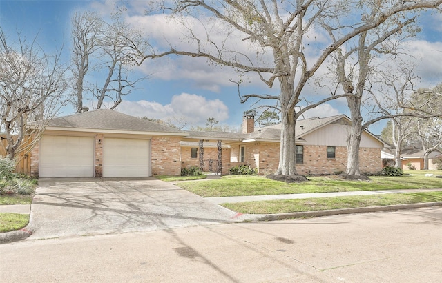 view of front facade with brick siding, concrete driveway, a chimney, an attached garage, and a front yard