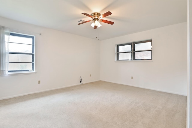 unfurnished room with light carpet, ceiling fan, visible vents, and baseboards