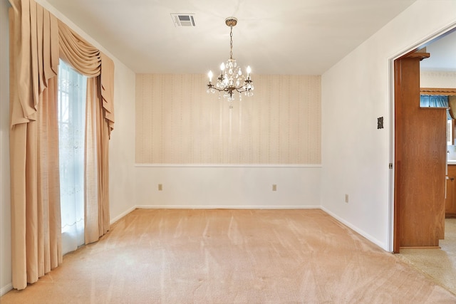 carpeted empty room featuring baseboards, wallpapered walls, visible vents, and a notable chandelier