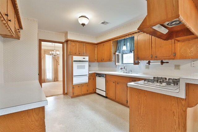 kitchen featuring a warming drawer, white appliances, brown cabinetry, and wallpapered walls