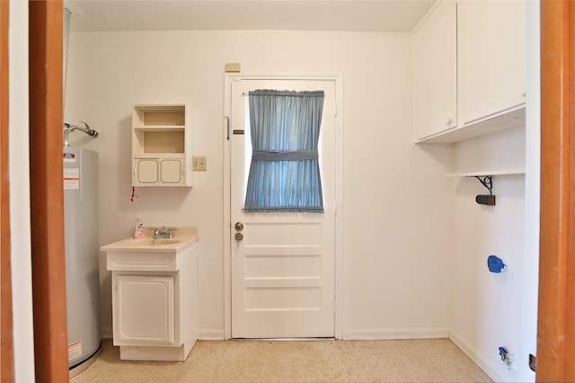 washroom with water heater, baseboards, and a sink