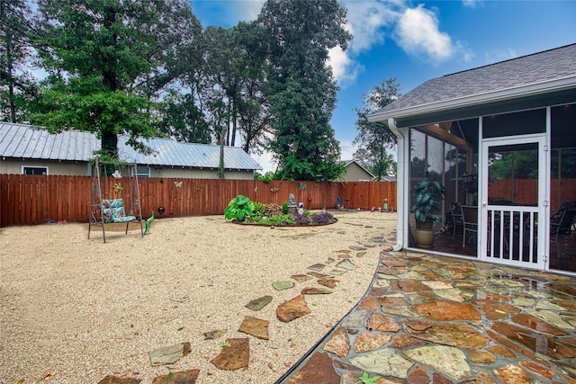 view of yard featuring a fenced backyard and a sunroom