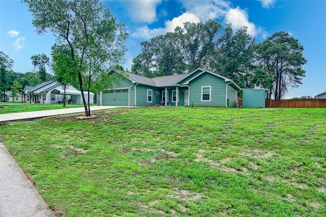 single story home with a garage, a front yard, driveway, and fence