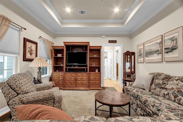 living room featuring visible vents, a raised ceiling, a wealth of natural light, and crown molding