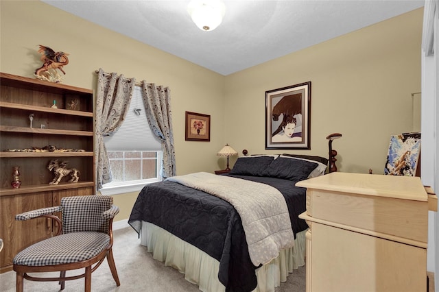 bedroom with light colored carpet and baseboards