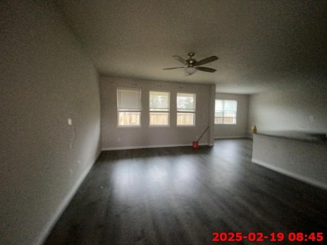 unfurnished living room with ceiling fan, dark wood-style flooring, a textured ceiling, and baseboards