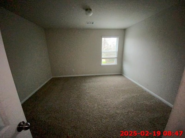 carpeted empty room featuring baseboards and visible vents