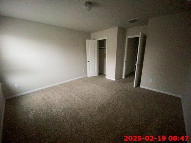 unfurnished bedroom featuring carpet floors, baseboards, and visible vents