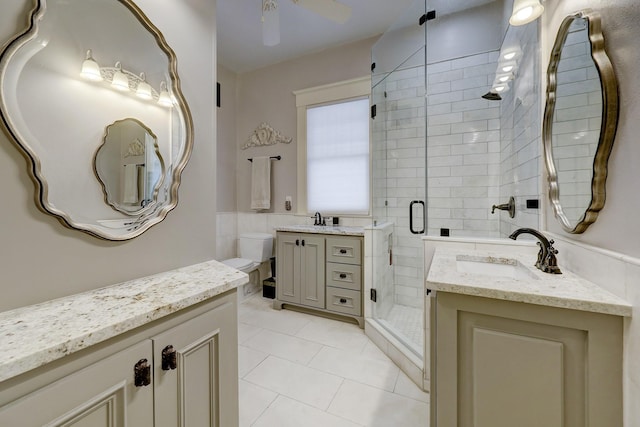 full bath with tile patterned flooring, two vanities, a stall shower, and a sink