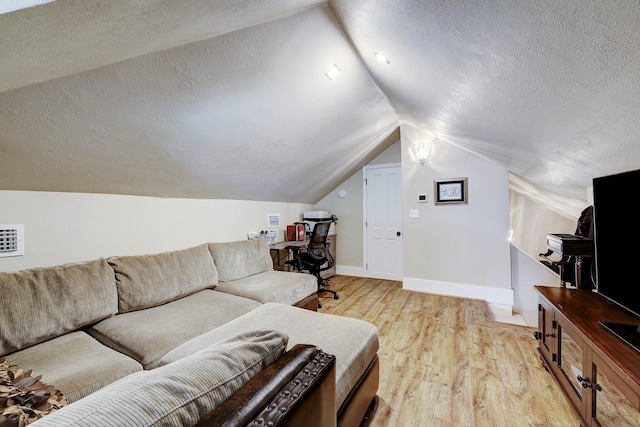 living area featuring light wood-type flooring, lofted ceiling, a textured ceiling, and baseboards