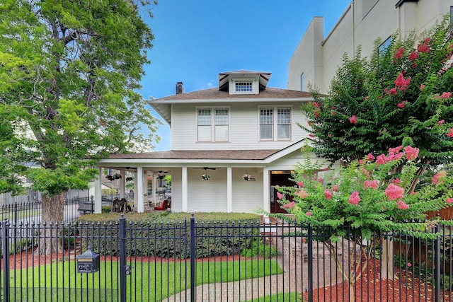 view of front of home with a fenced front yard, roof with shingles, a porch, and a ceiling fan