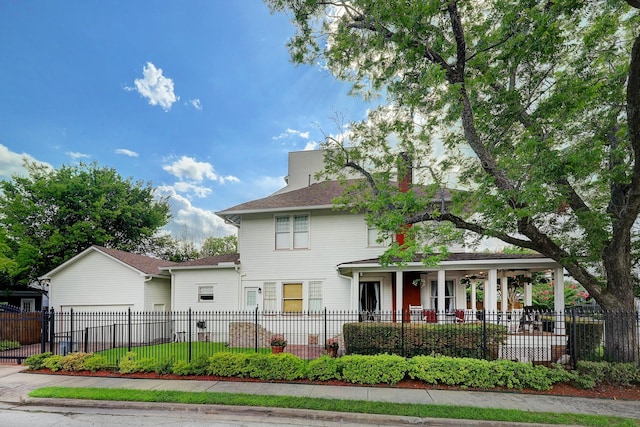 view of front of property with a fenced front yard, a chimney, and an attached garage