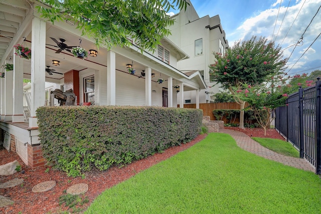 view of yard with ceiling fan and fence