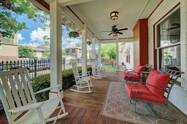 wooden deck featuring a porch, a ceiling fan, and fence