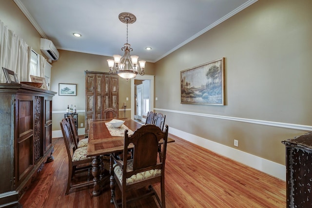 dining space featuring a chandelier, ornamental molding, baseboards, and wood finished floors