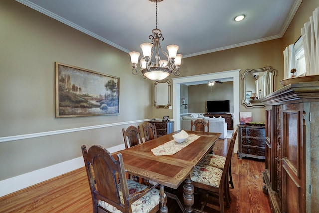 dining area featuring crown molding, wood finished floors, and baseboards