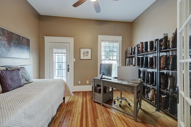 bedroom with a ceiling fan, baseboards, and wood finished floors