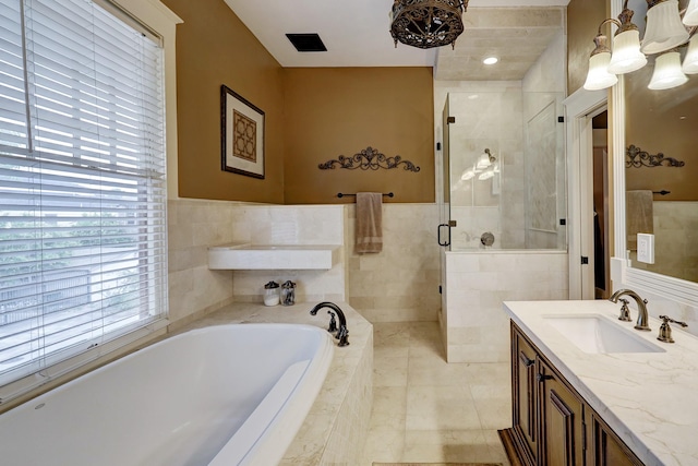 full bathroom with tile patterned floors, a garden tub, tile walls, a shower stall, and vanity