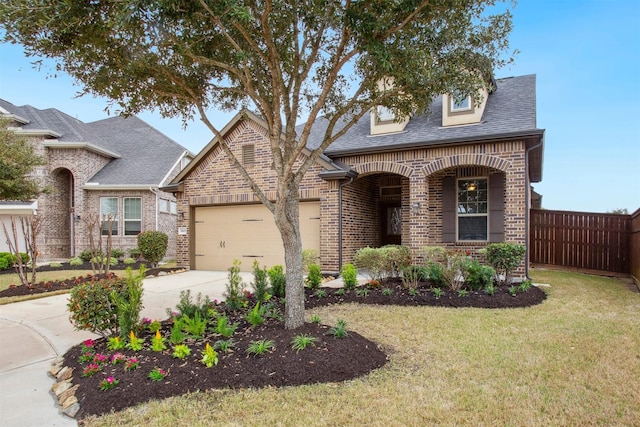 view of front of home featuring a garage, a front yard, fence, and brick siding