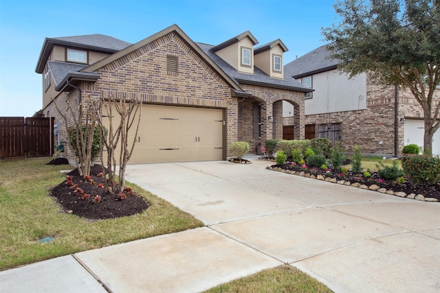 view of front of house with a garage, brick siding, fence, concrete driveway, and a front yard