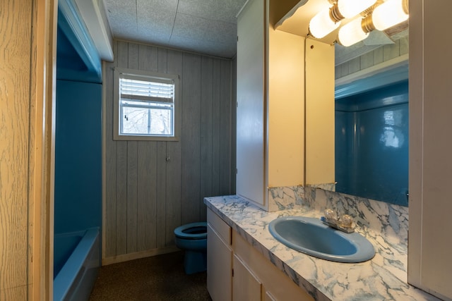 full bath featuring wood walls, vanity, toilet, and a bathing tub