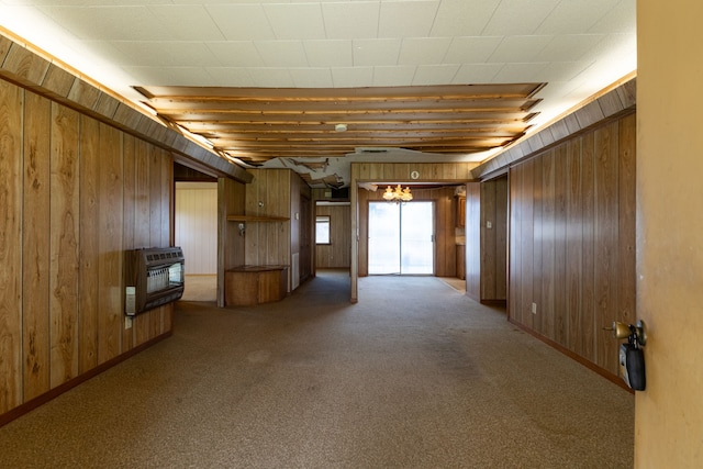 interior space with wooden walls, carpet, and heating unit