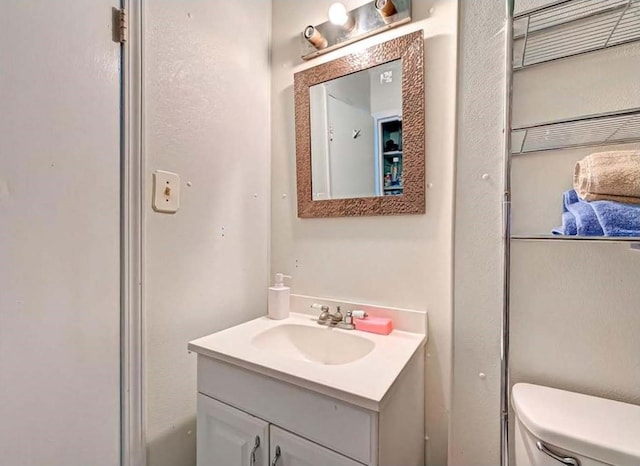 bathroom featuring toilet and vanity