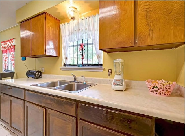 kitchen with brown cabinets, light countertops, and a sink