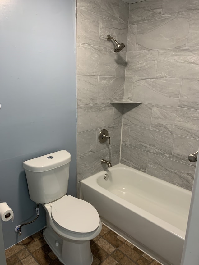 bathroom with bathtub / shower combination, toilet, and stone tile floors