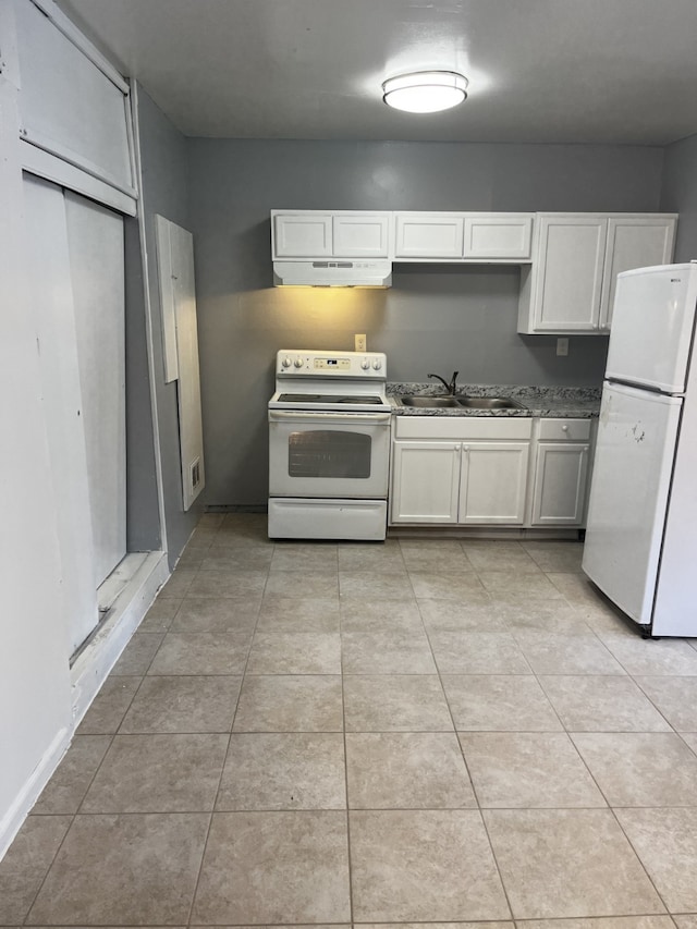 kitchen featuring white appliances, white cabinets, a sink, and light tile patterned flooring