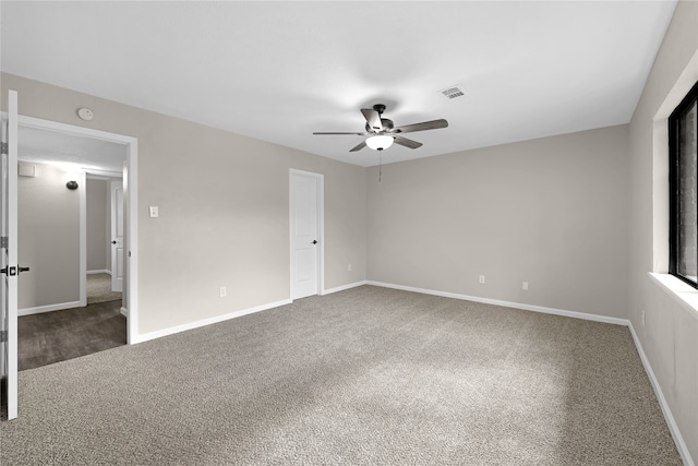 spare room featuring carpet, visible vents, ceiling fan, and baseboards