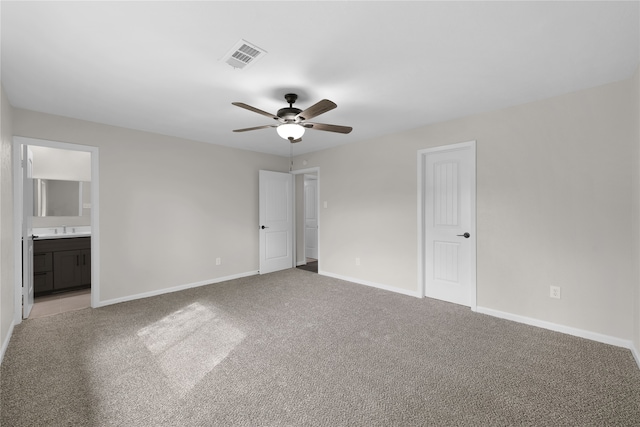 unfurnished bedroom featuring visible vents, ensuite bathroom, a ceiling fan, light carpet, and baseboards