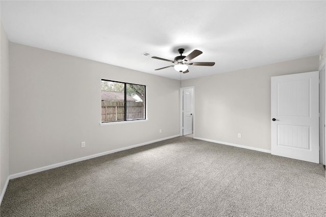 carpeted empty room with visible vents, a ceiling fan, and baseboards