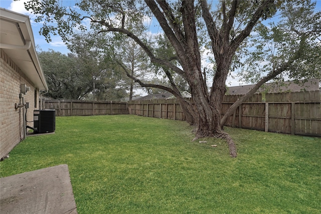 view of yard featuring a fenced backyard and central AC