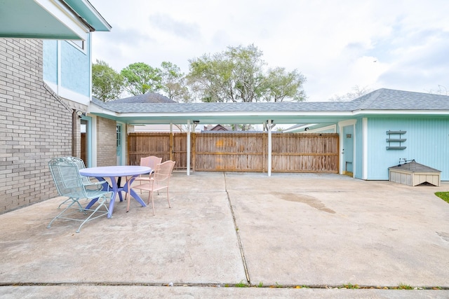 view of patio with a carport and fence