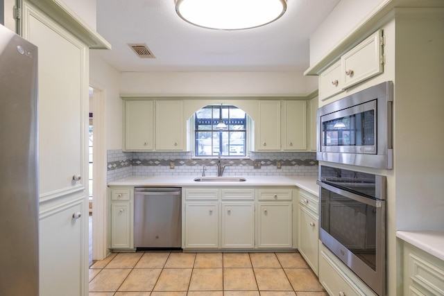 kitchen with decorative backsplash, visible vents, stainless steel appliances, and a sink