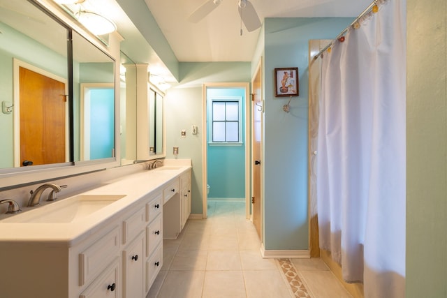 full bath featuring double vanity, a ceiling fan, a sink, tile patterned flooring, and baseboards