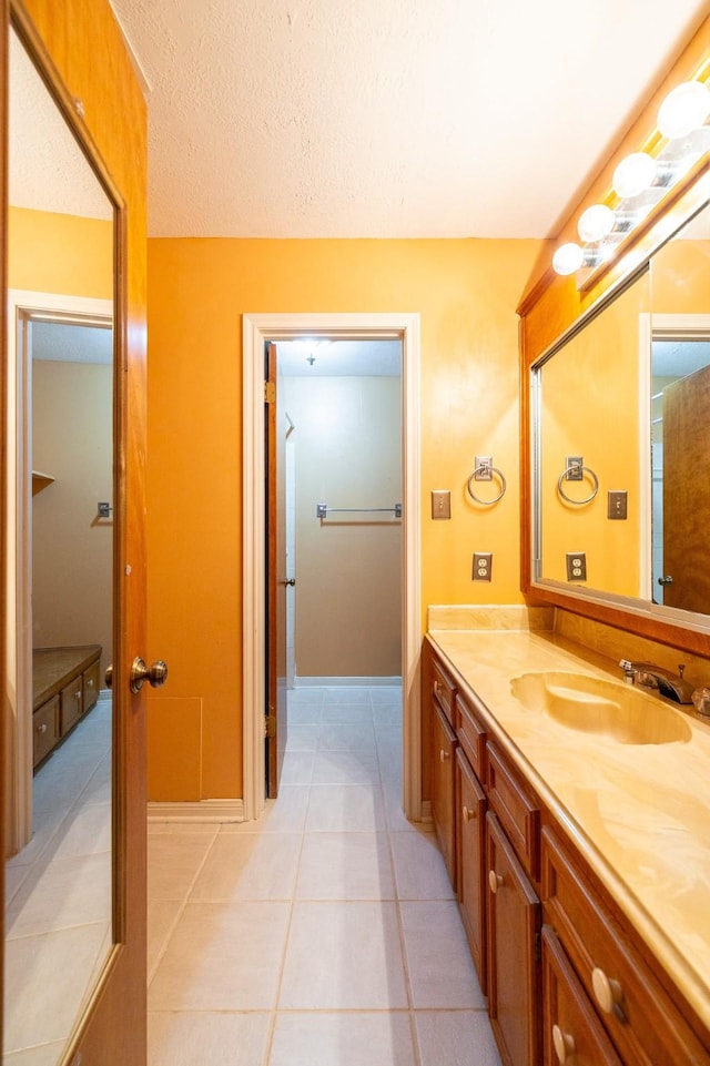 bathroom featuring tile patterned flooring, vanity, and a textured ceiling