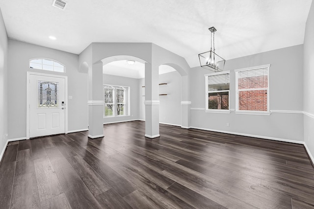 foyer entrance with dark wood-style floors, baseboards, visible vents, and a wealth of natural light