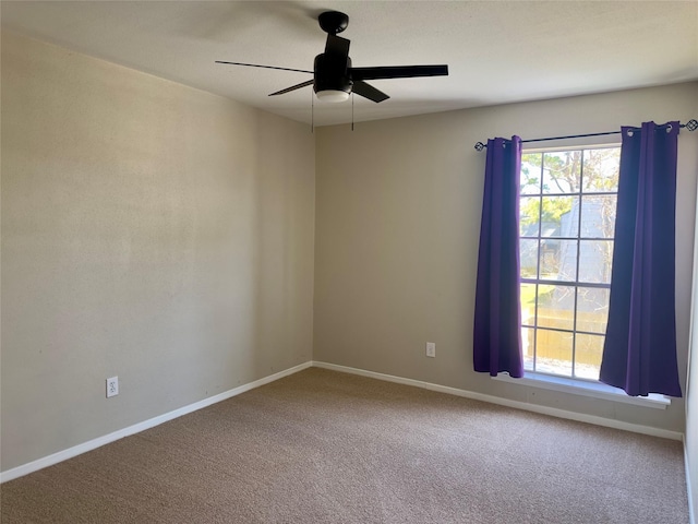 unfurnished room featuring carpet flooring, a ceiling fan, and baseboards