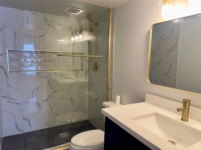 bathroom with a marble finish shower, visible vents, vanity, and toilet