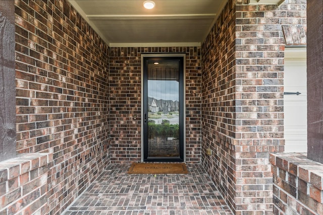 entrance to property featuring brick siding