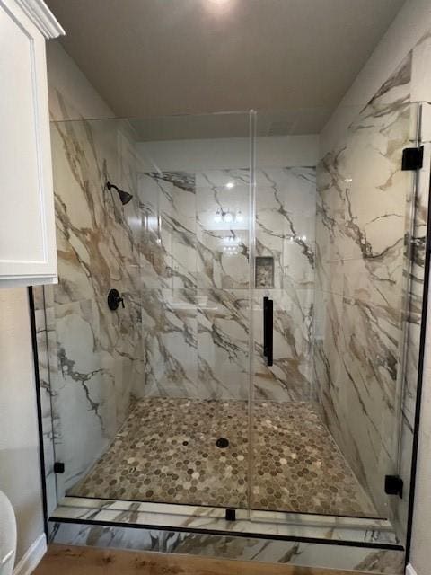 full bathroom with a marble finish shower